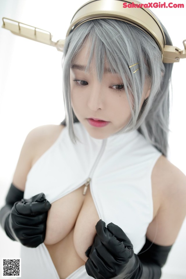 A woman in a white top and black gloves posing for a picture.