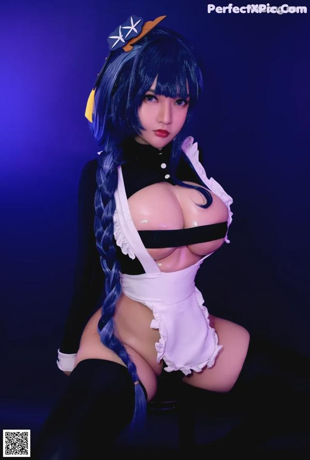 A woman in a maid outfit posing for a picture.