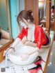 A woman in a red leather outfit is washing her hands in a sink.