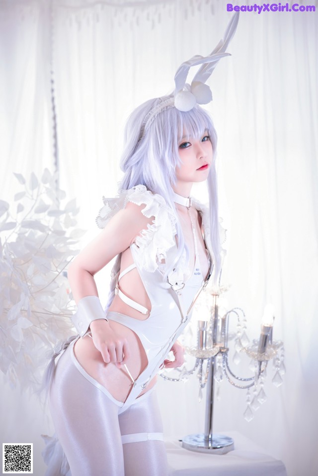 A woman in a white bunny costume posing for a picture.